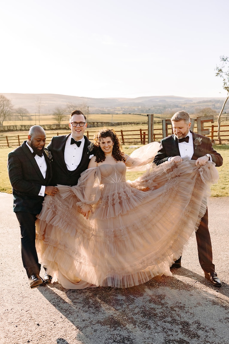 Bride and groom posing with family during group photos at The Wellbeing Farm wedding venue.