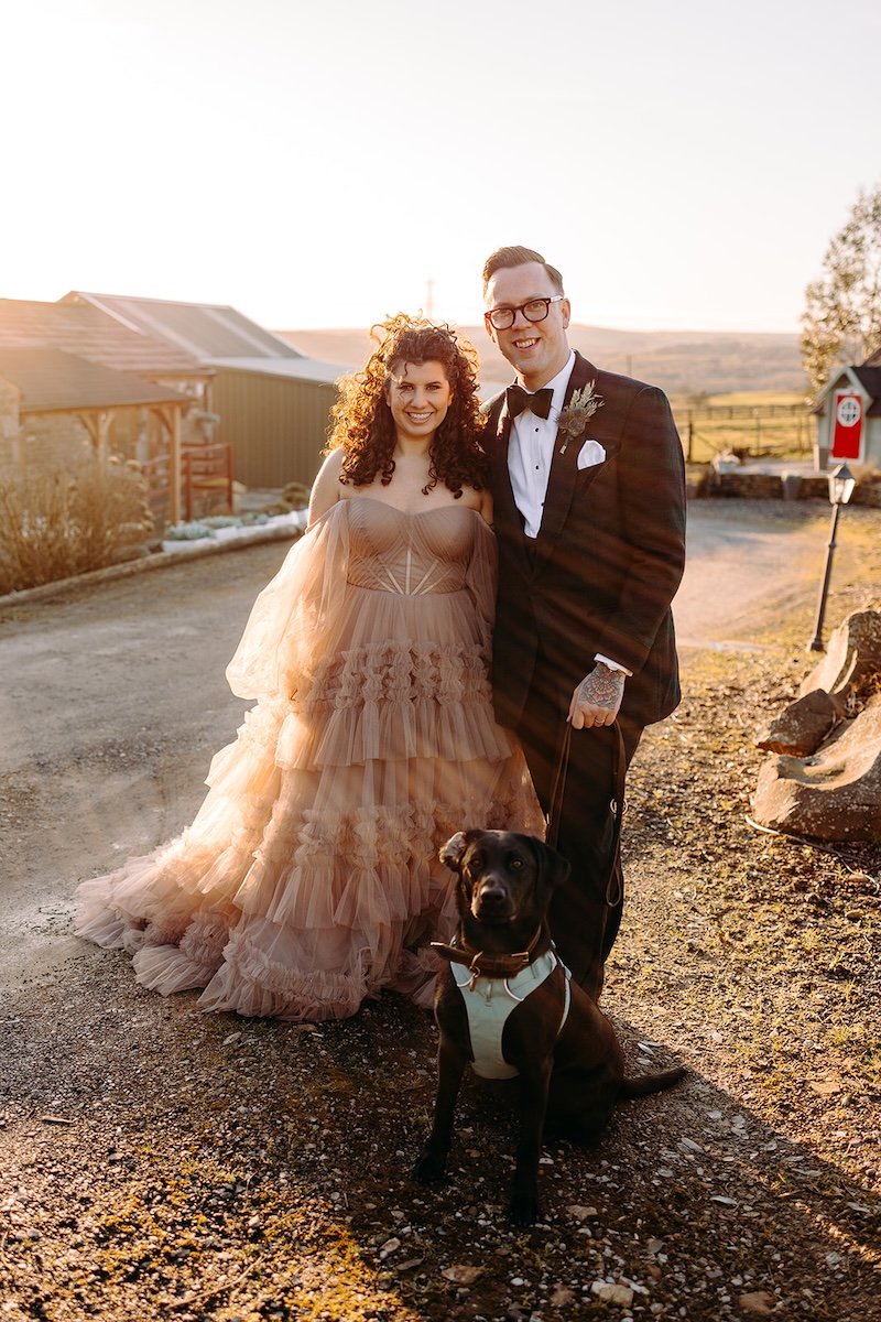 Bride and groom standing together with their dog during golden hour wedding photography at The Wellbeing Farm.