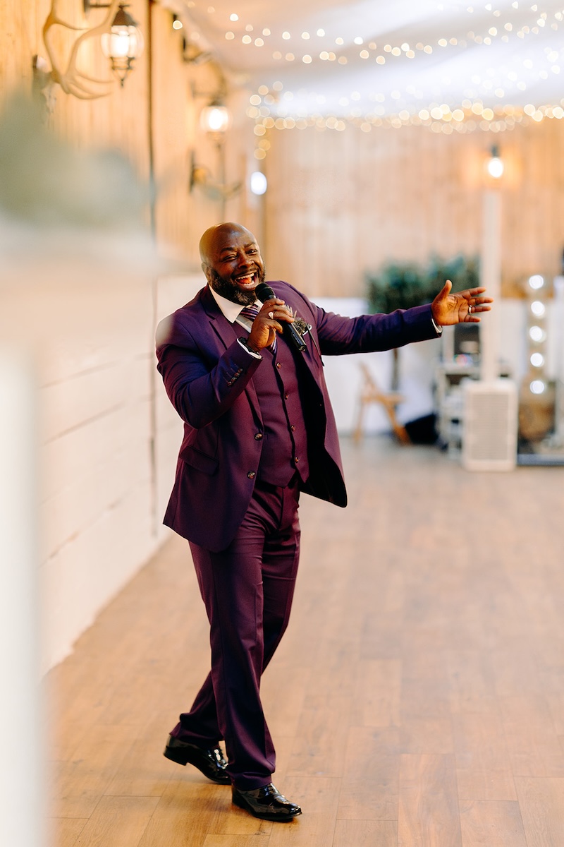 Master of ceremonies announcing bride and groom into the reception barn at The Wellbeing Farm.