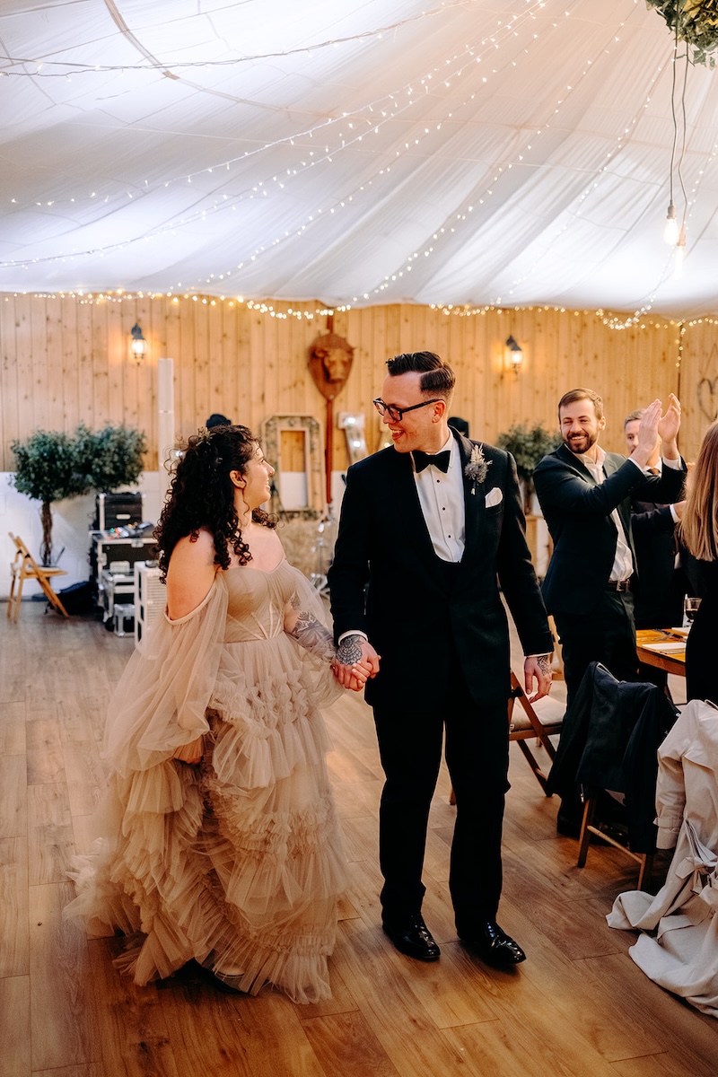 Bride and groom entering the reception room together during their February wedding celebration.