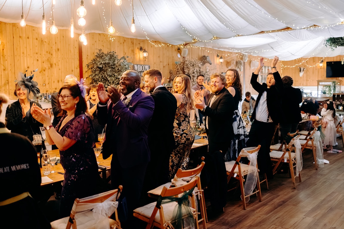 Guests clapping and celebrating during the wedding breakfast at The Wellbeing Farm.