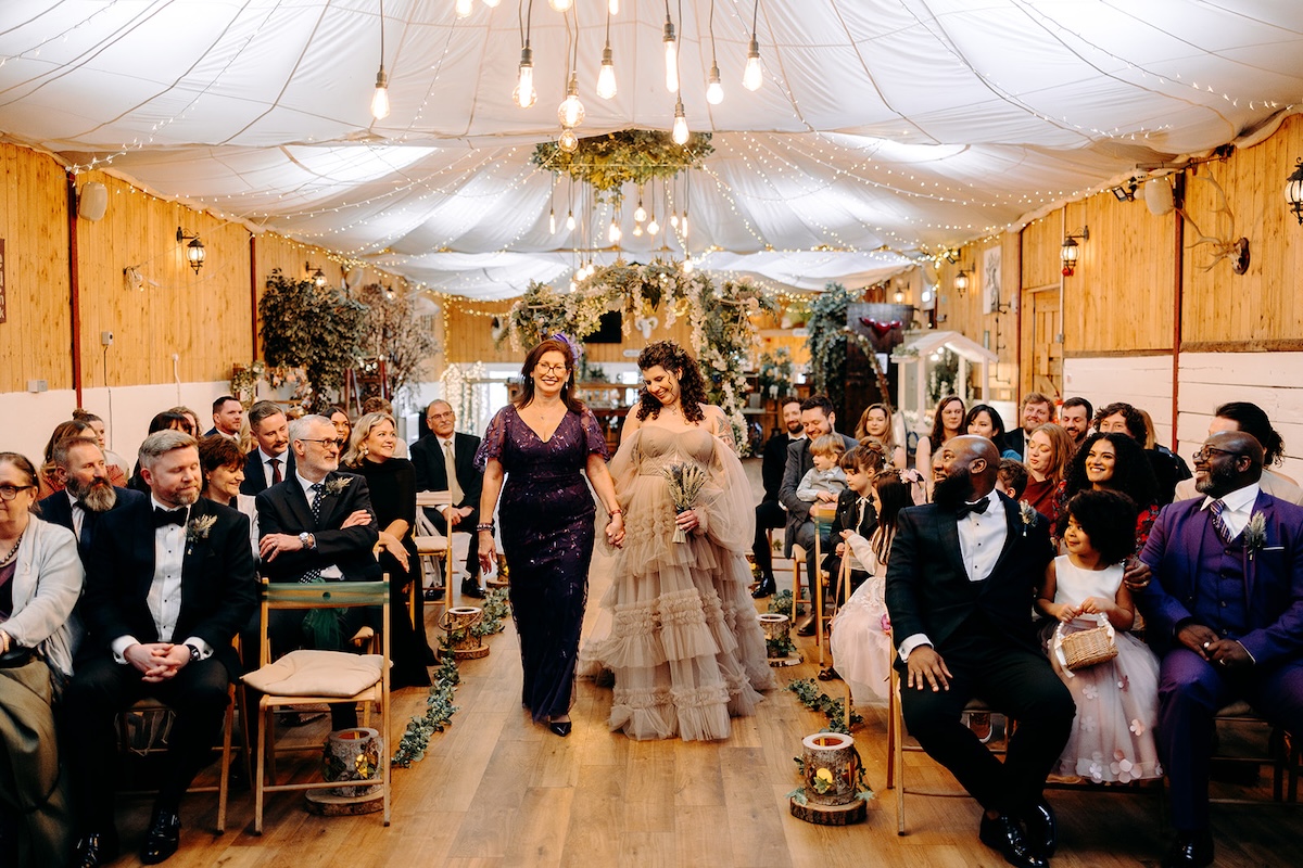 Guests watching the bridal party processional during a February wedding ceremony at The Wellbeing Farm, photographed with relaxed documentary wedding photography.