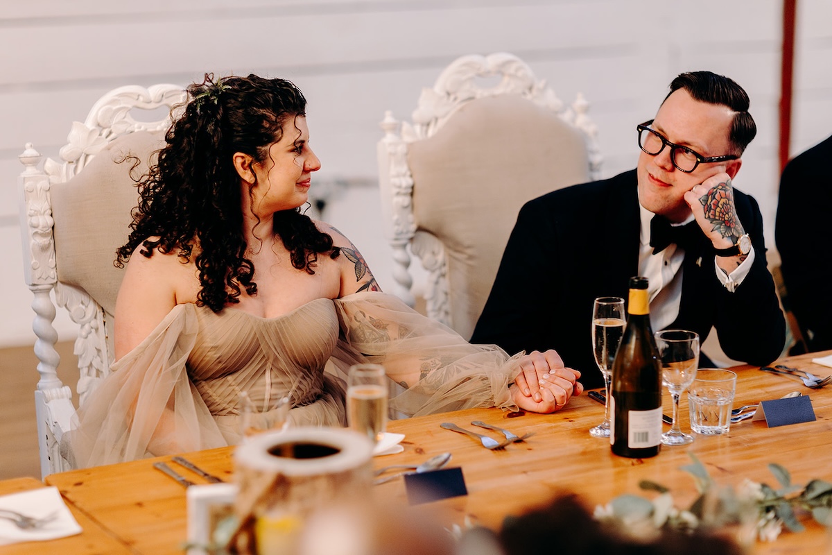 Bride reacting and laughing during the speeches photographed with documentary wedding photography.