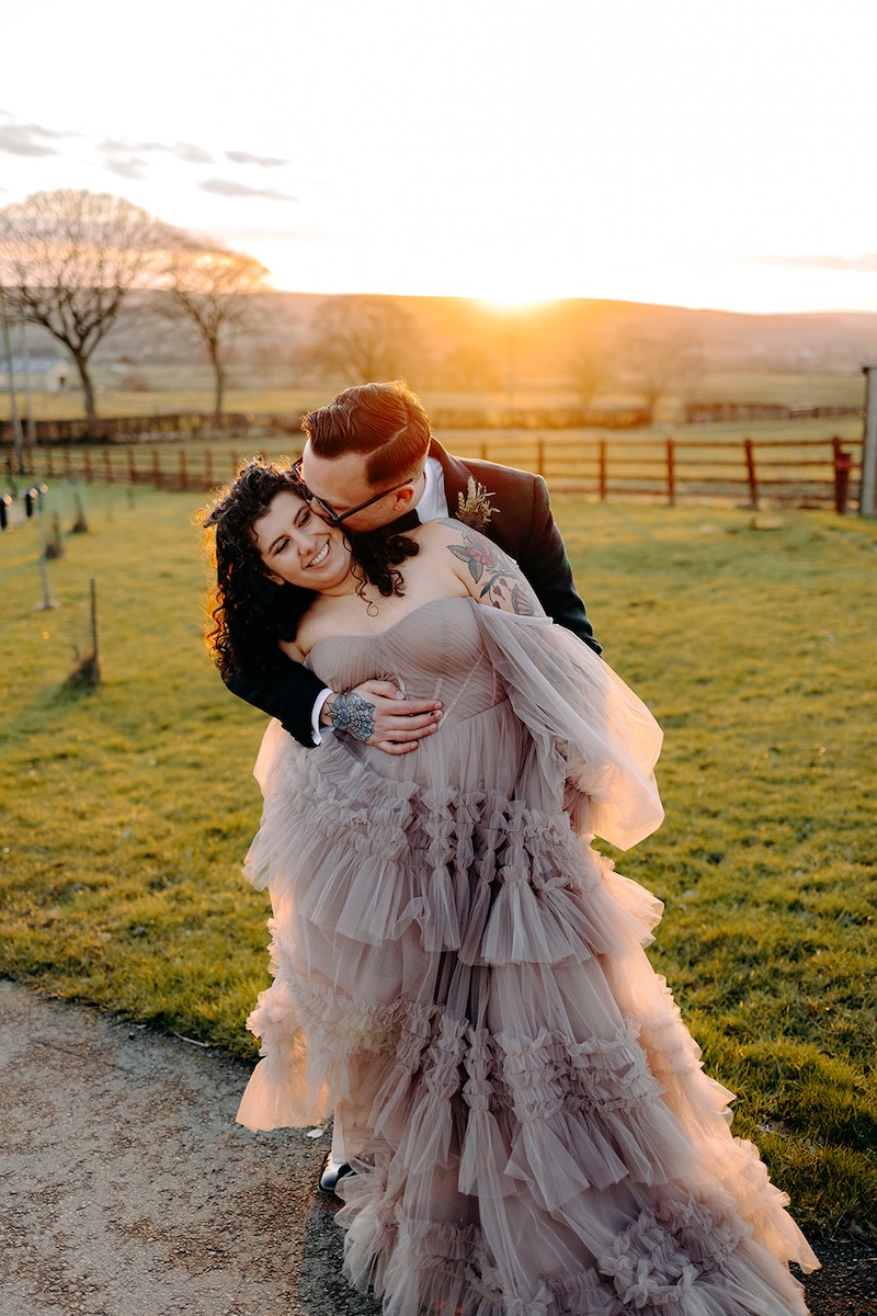 Bride and groom hugging during sunset portraits outside the venue photographed by a wedding photographer.