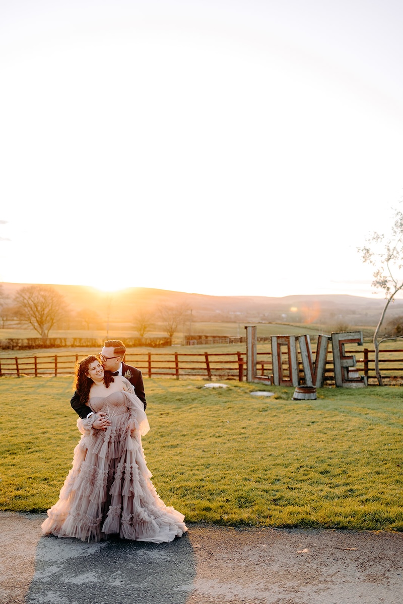 Bride and groom embracing in warm evening light during winter wedding photography portraits.