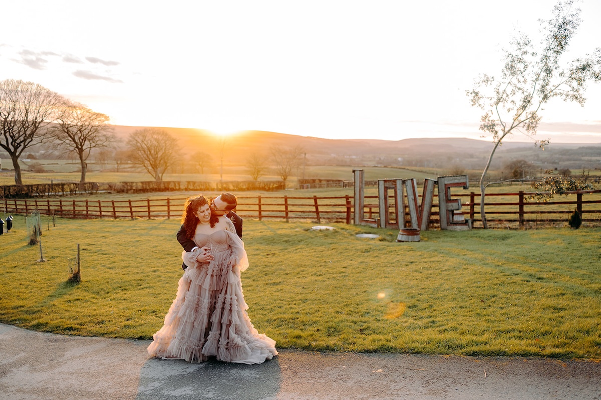 Bride and groom embracing in warm evening light during winter wedding photography portraits.