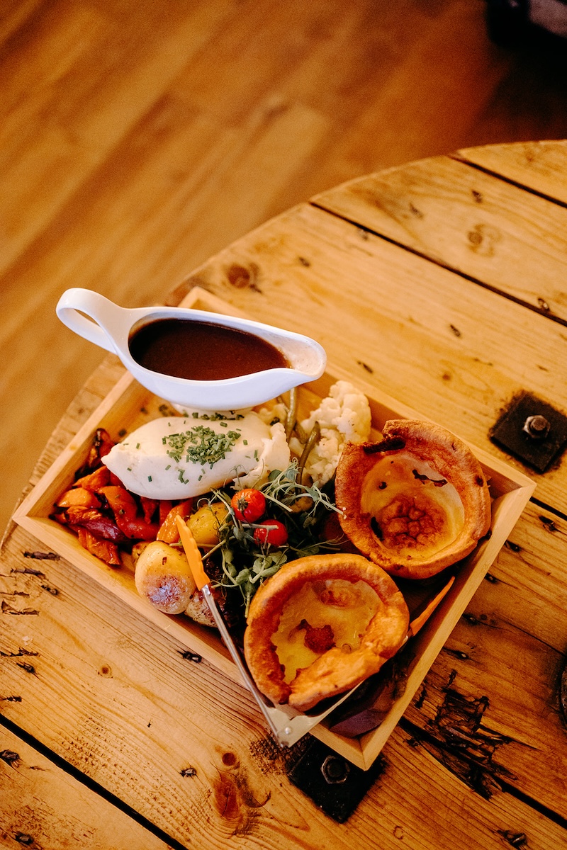 Wooden sharing platter with roasted vegetables and sides served during the wedding meal at The Wellbeing Farm.