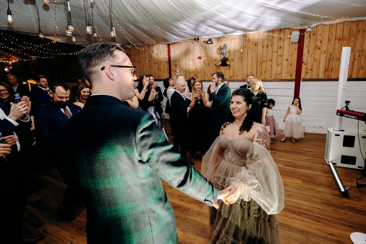 Guests dancing together during the evening celebration at The Wellbeing Farm wedding reception.