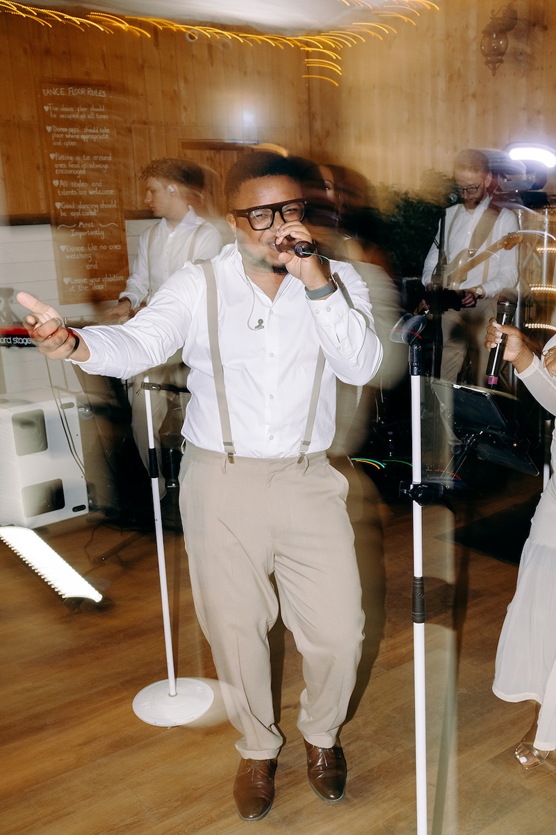 Singer performing with the live wedding band during the reception party at The Wellbeing Farm.
