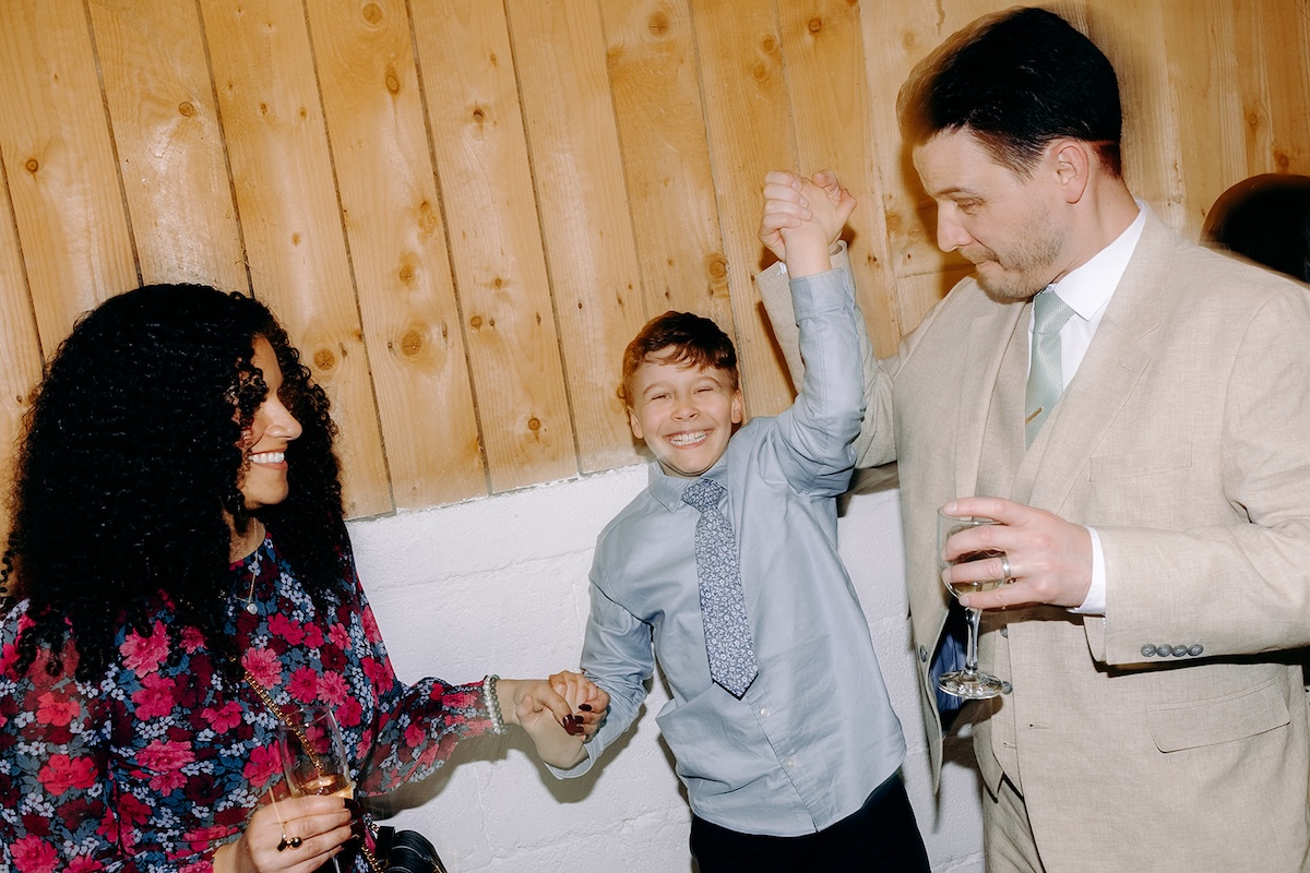 Guests dancing and laughing together on the dancefloor captured with natural wedding photography.
