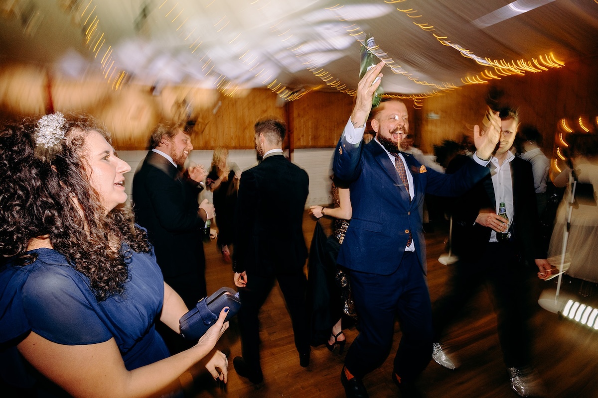 Wedding guests celebrating and dancing enthusiastically during the evening reception.