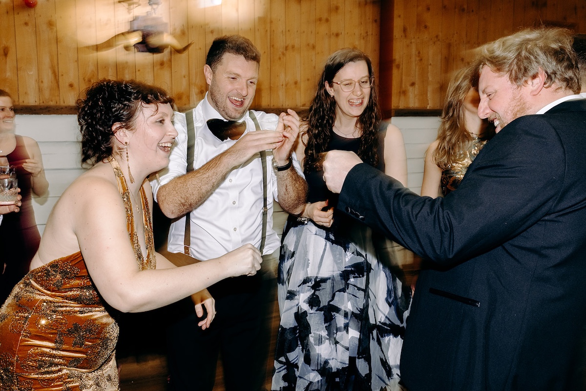 Bride dancing joyfully with guests during the evening wedding party photographed by a wedding photographer.