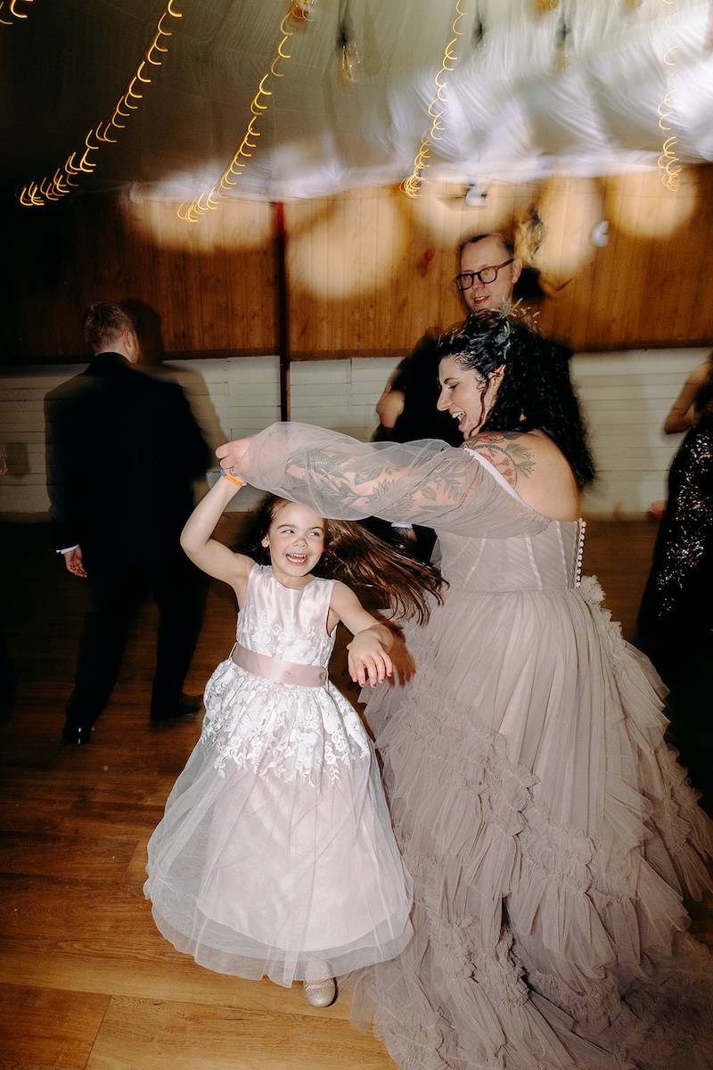 Bride dancing with young flower girls during the wedding reception at The Wellbeing Farm.