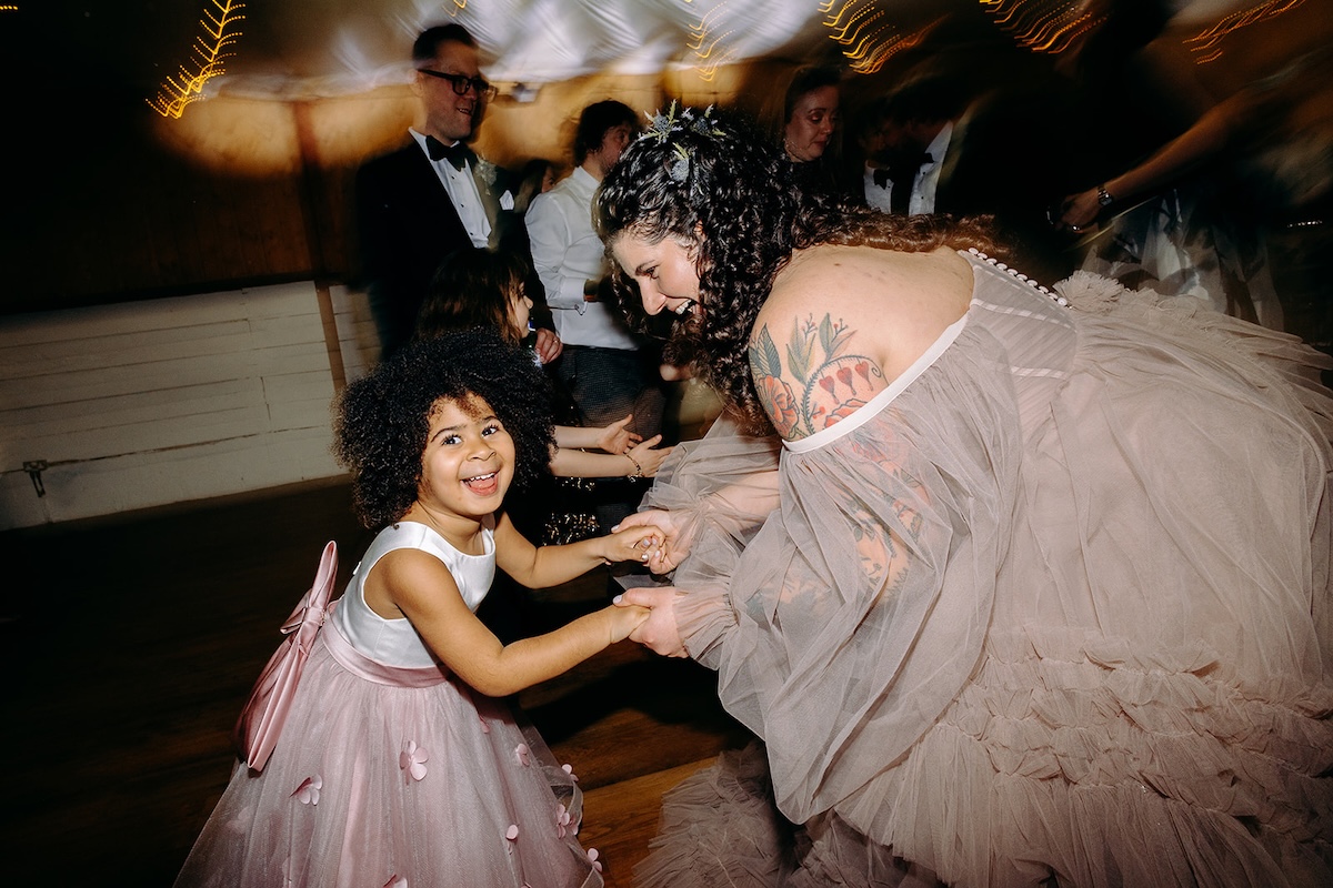 Bride dancing with children on the dancefloor during the evening celebration photographed with documentary wedding photography.