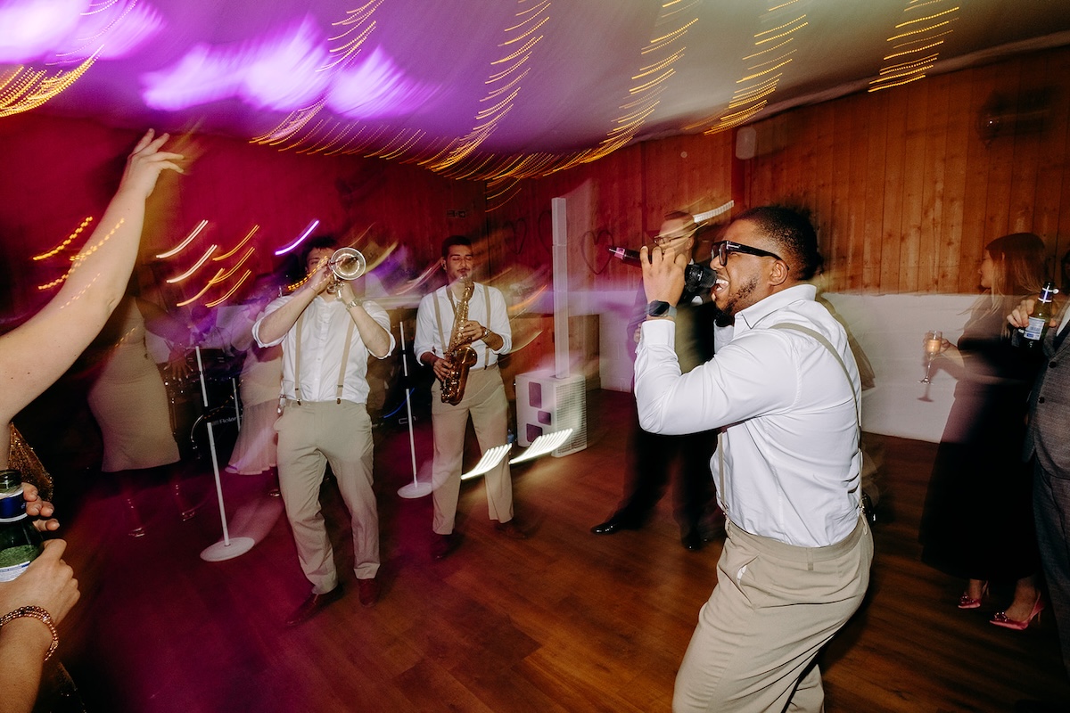 Singer performing energetically with the live wedding band during the reception celebration.