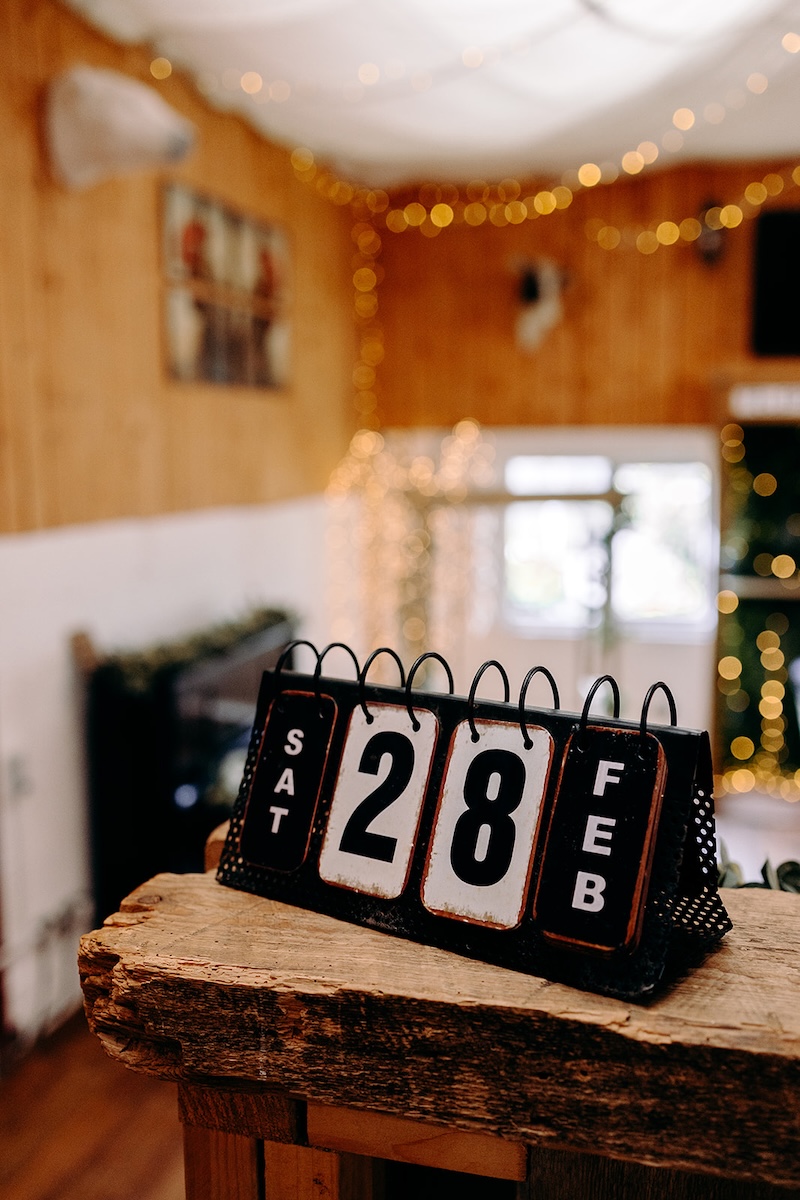 Wooden calendar blocks showing the wedding date inside the barn at The Wellbeing Farm, a detail captured with natural wedding photography during a February wedding.