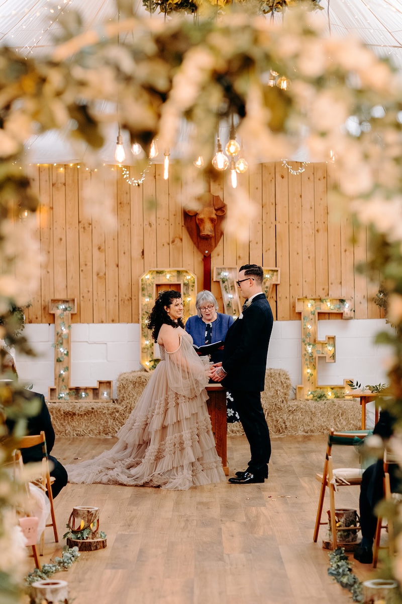 Bride laughing during the ceremony at her February wedding at The Wellbeing Farm, photographed with documentary wedding photography.
