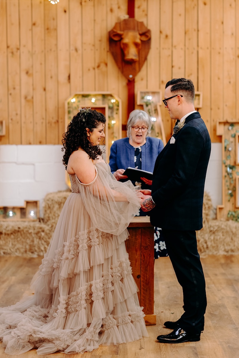 Groom reading vows during the ceremony at The Wellbeing Farm sustainable wedding venue, captured with natural wedding photography.