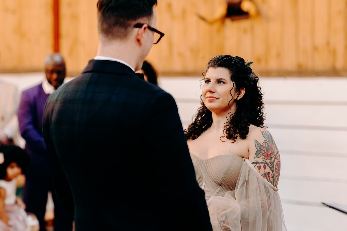 Bride and groom smiling at each other during their February wedding ceremony at The Wellbeing Farm, captured with relaxed natural wedding photography.