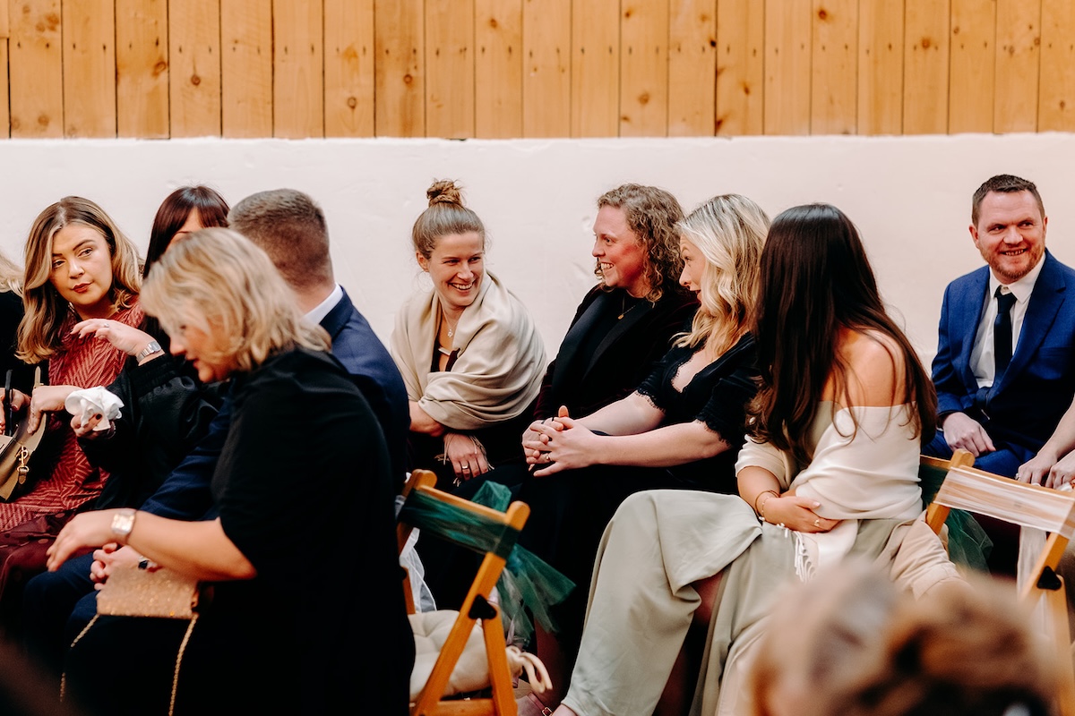 Guests smiling and reacting during the ceremony at The Wellbeing Farm winter wedding.