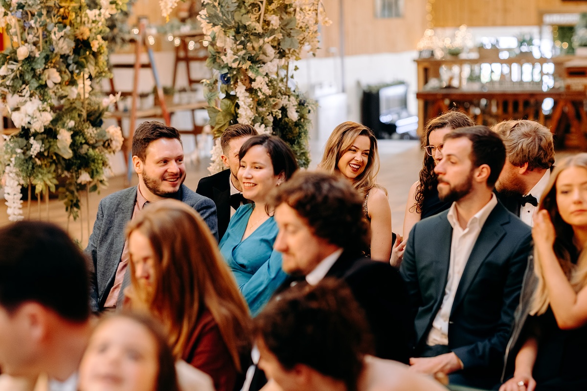 Wedding guests watching the ceremony inside the decorated barn venue in Lancashire.