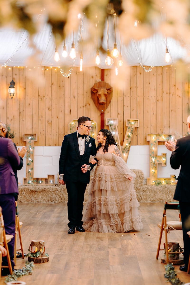 Newly married couple standing together after signing the register at The Wellbeing Farm wedding ceremony.