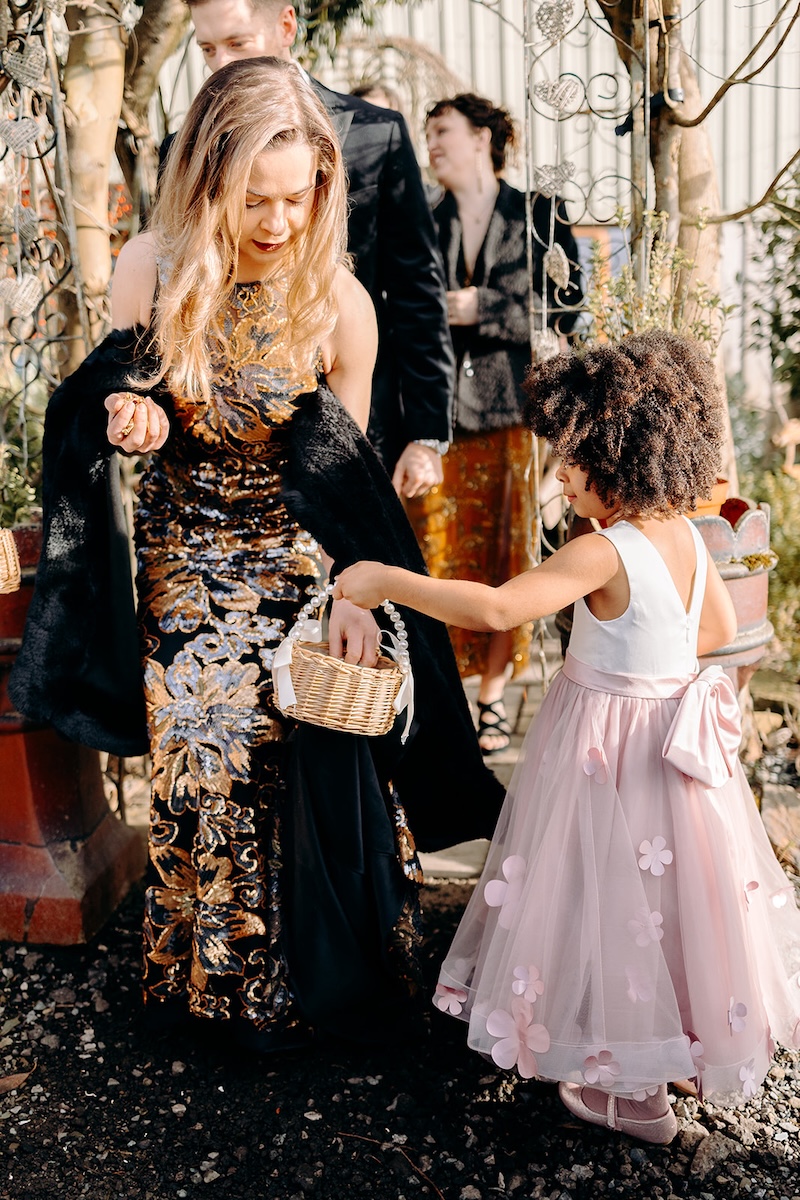 Young flower girls walking together outside the barn after the ceremony.