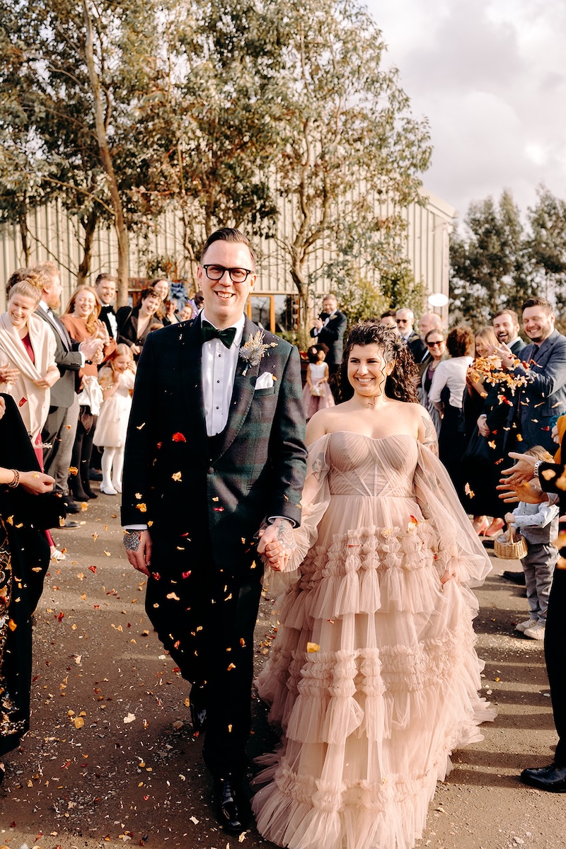 Colourful confetti moment outside The Wellbeing Farm captured with natural documentary wedding photography.