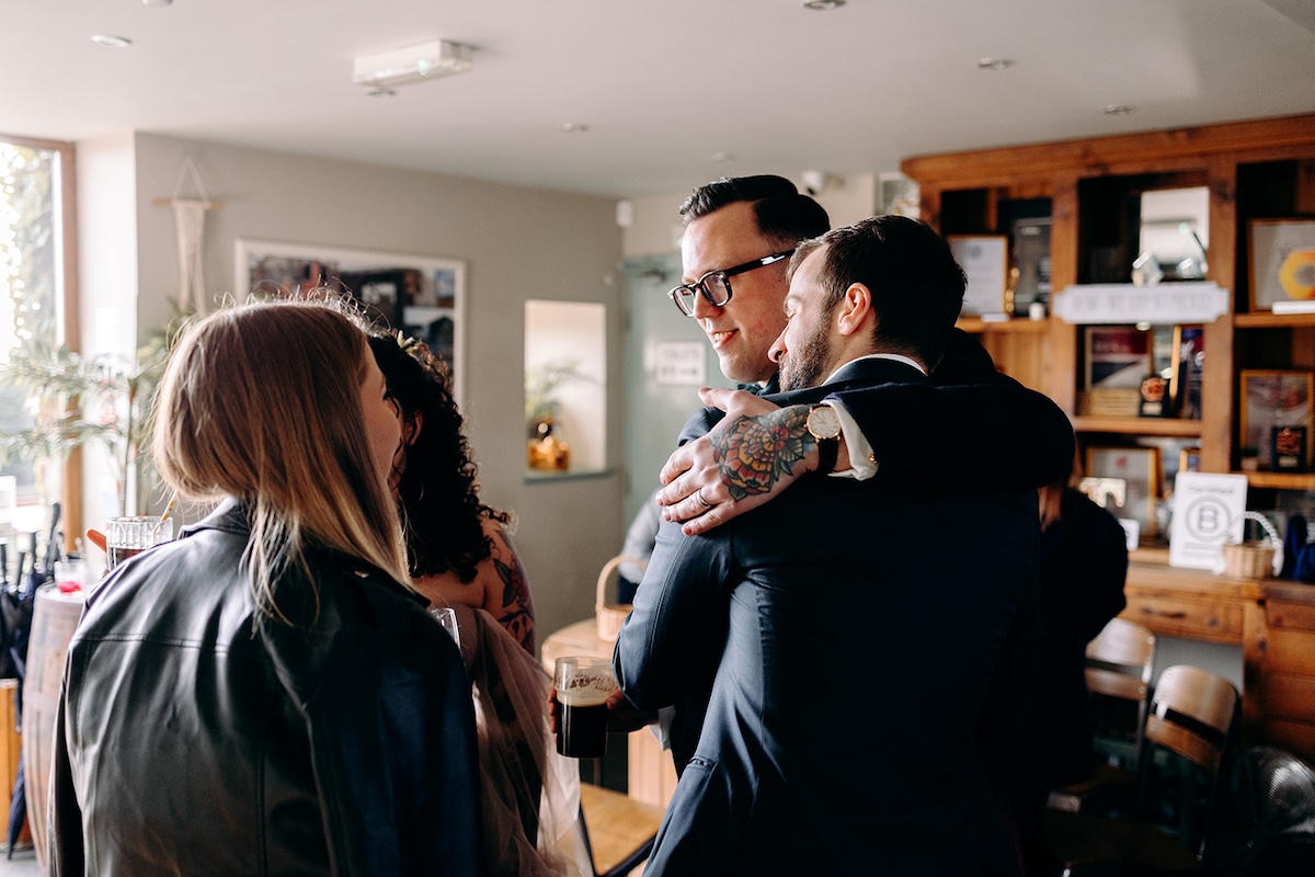 Wedding guests greeting each other inside the barn during the February wedding celebration.