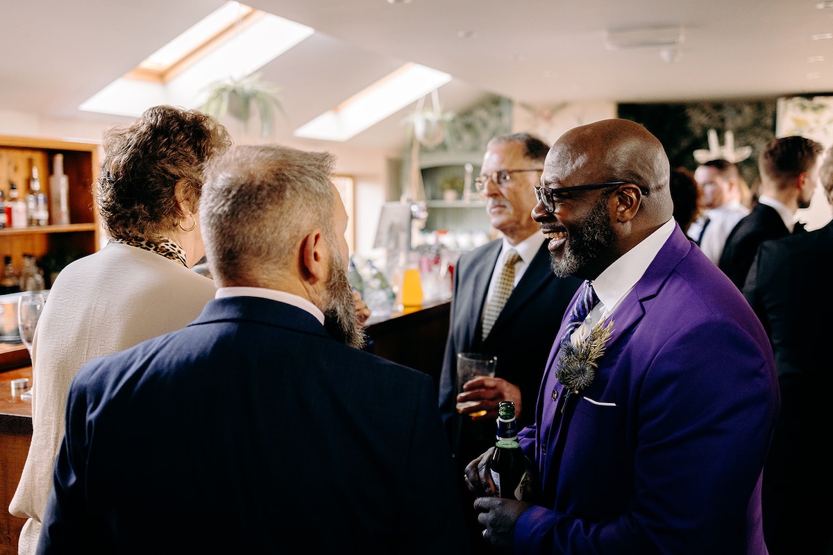 Guests laughing and chatting together during the drinks reception, captured with relaxed wedding photography.