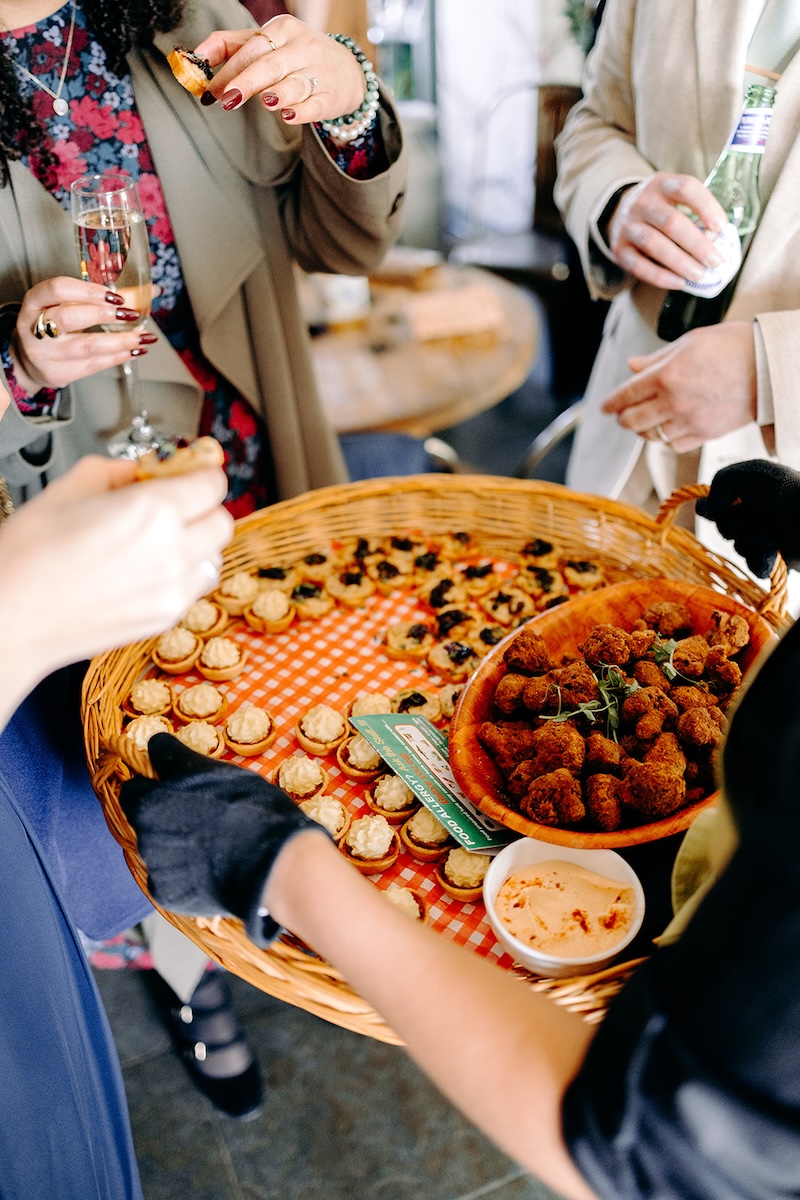 Staff carrying trays of colourful canapés during the reception at The Wellbeing Farm.