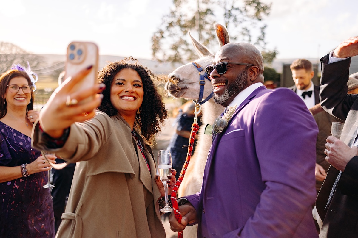 Guests taking photos together during the drinks reception outside The Wellbeing Farm.