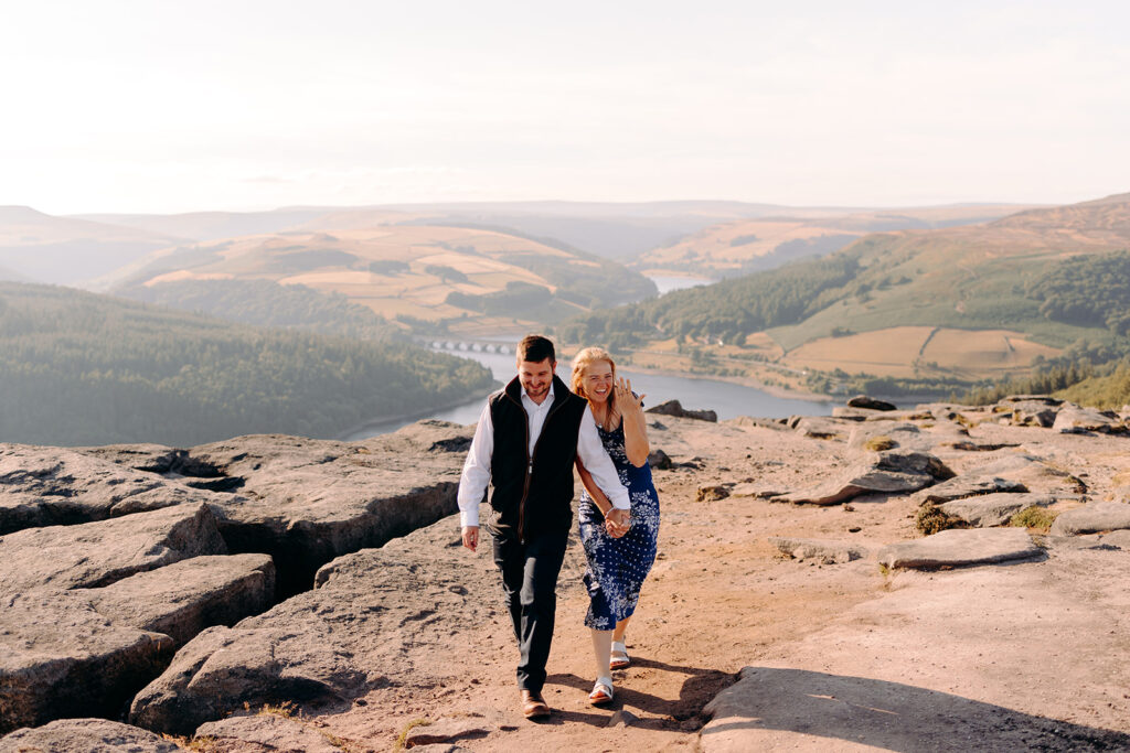 Couple exploring a rocky Peak District viewpoint after their proposal