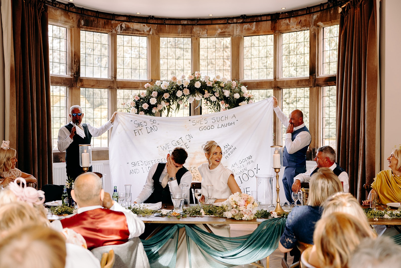 Wedding speeches beneath a large personalised banner at the Thornbridge Hall reception.