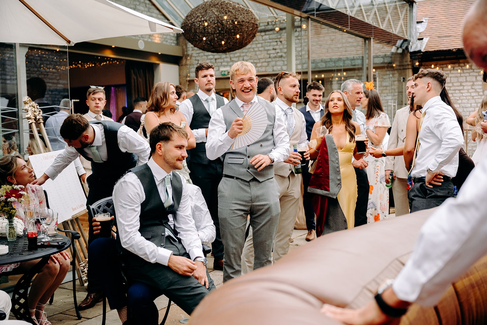 Guests laughing and watching the bucking bronco at this fun Derbyshire wedding.