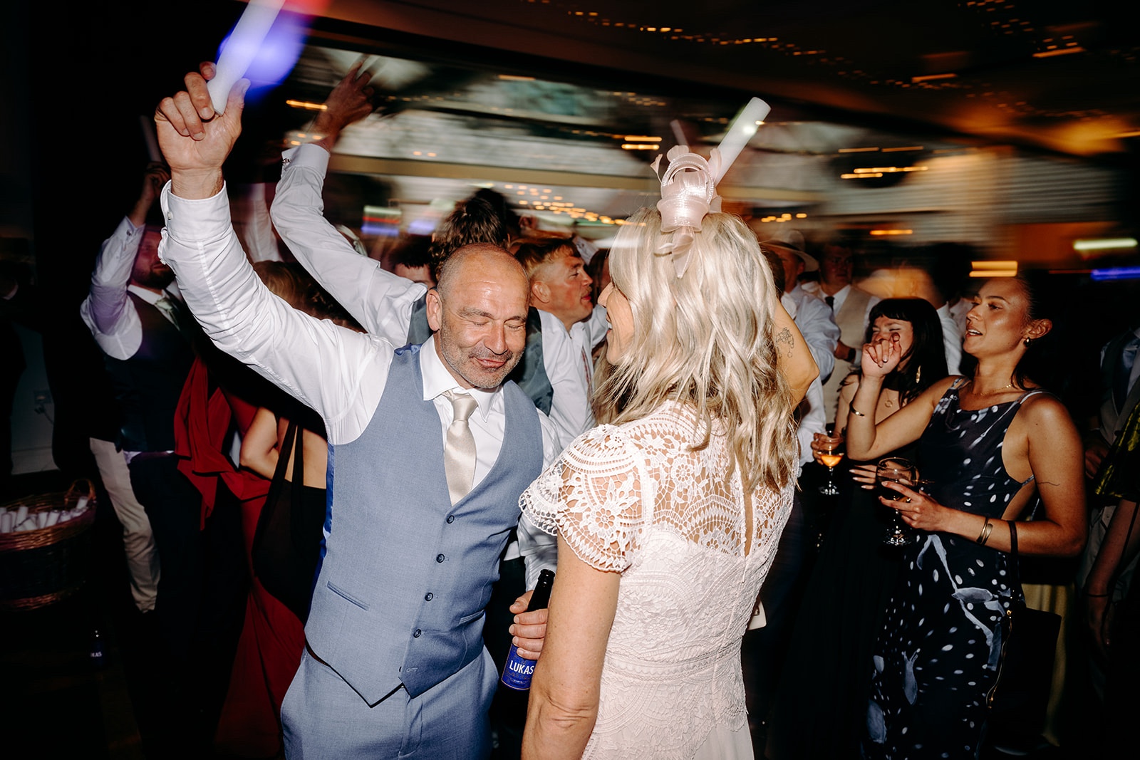 Wedding guests throwing their hands in the air during a lively Thornbridge Hall party.