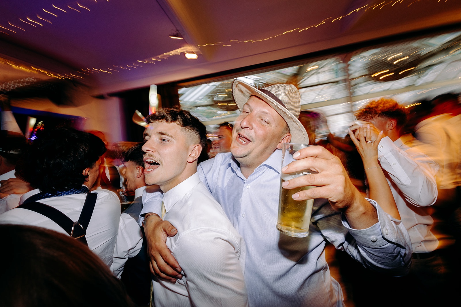 Wedding guest dancing with a drink during the evening party.