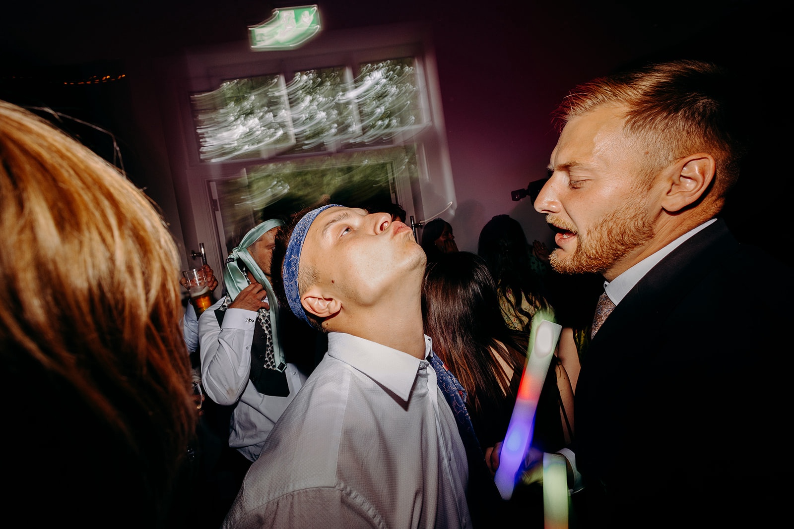 Wedding guests dancing under colourful lights during the late-night reception.
