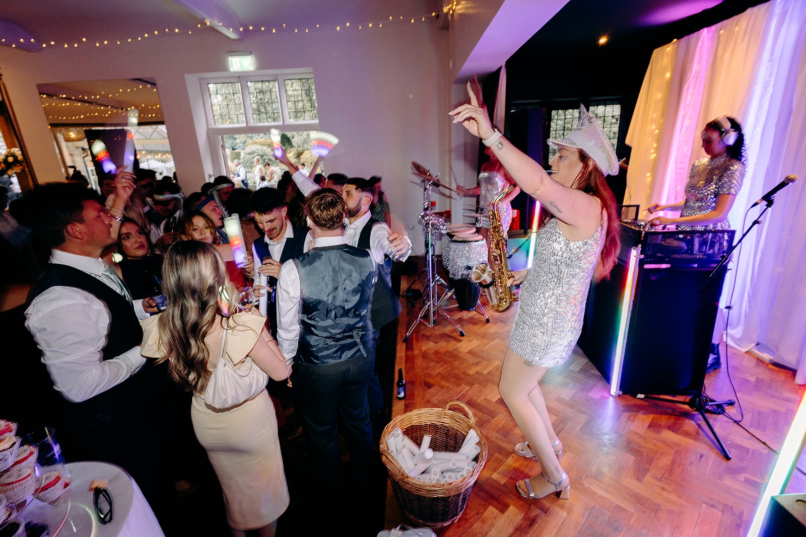 Wedding guests throwing their arms in the air during the energetic evening reception.