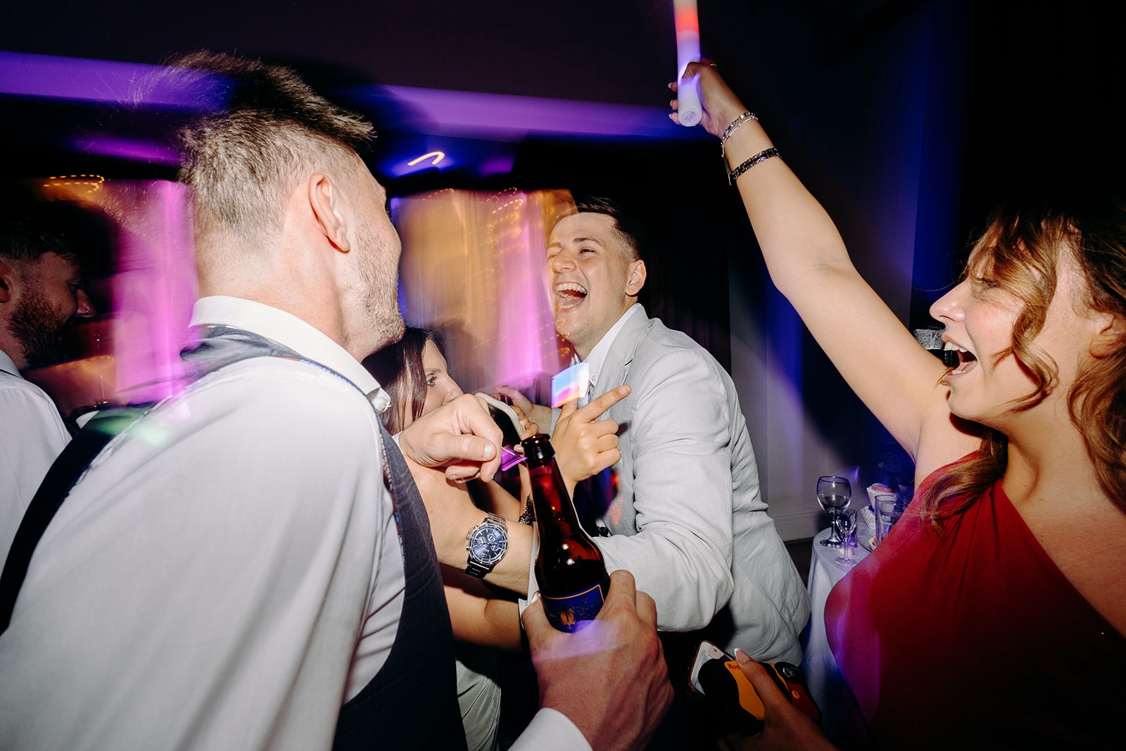 Wedding guest dancing with a drink during the evening party.