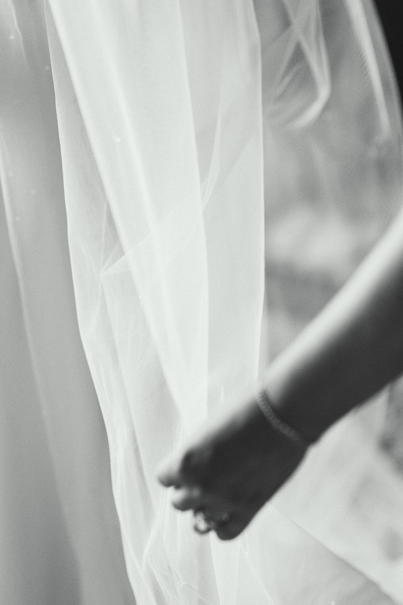 Close-up of a cathedral-length wedding veil before the outdoor ceremony at Thornbridge Hall.