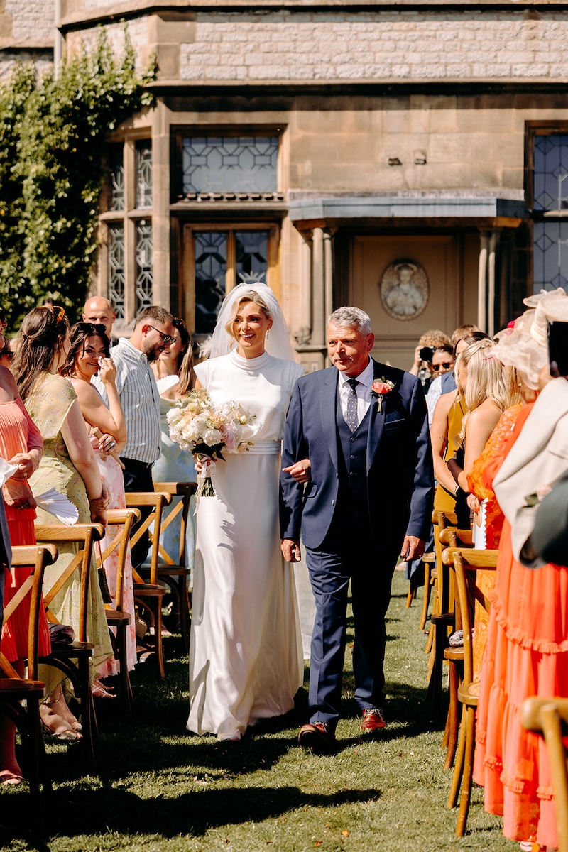 Bride and her father walking through Thornbridge Hall on their way to the ceremony.