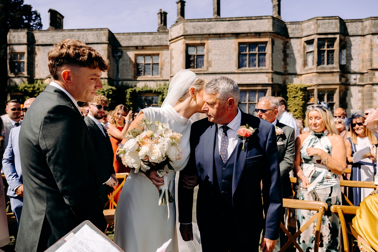 Bride walking down the aisle with her father at a summer wedding at Thornbridge Hall.