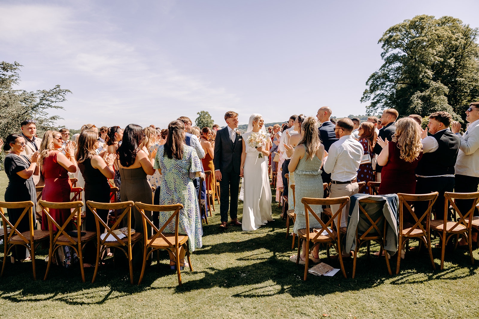 Wide view of a summer wedding ceremony on the lawn at Thornbridge Hall.