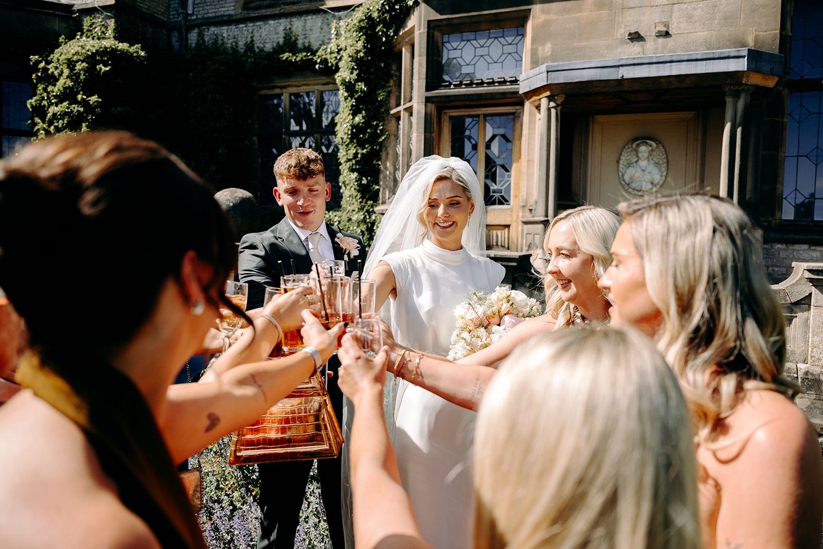 Bride chatting with friends and family outside Thornbridge Hall after the ceremony.