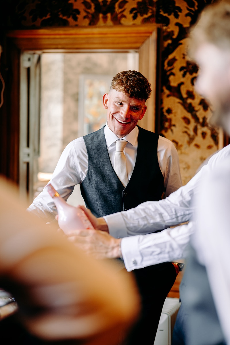 Groom getting ready with his groomsmen before his Peak District wedding at Thornbridge Hall.